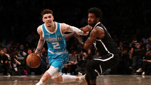 NEW YORK, NEW YORK - MARCH 27: LaMelo Ball #2 of the Charlotte Hornets drives to the basket against Kyrie Irving #11 of the Brooklyn Nets at Barclays Center on March 27, 2022 in New York City.
