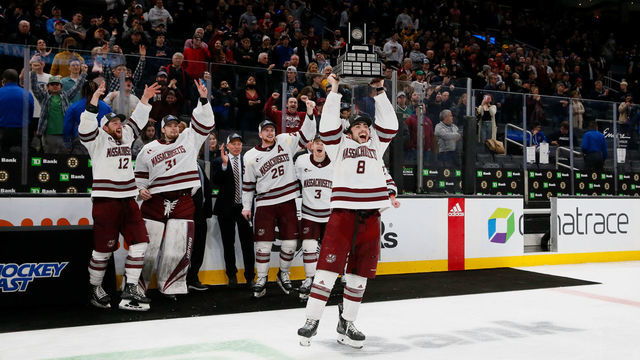 BOSTON, MA - MARCH 19: Bobby Trivigno #8 of the Massachusetts Minutemen raises the Lou Lamoriello Trophy after a 2-1 overtime victory against the Connecticut Huskies during NCAA men's hockey in the Hockey East Championship Final at TD Garden on March 19, 2022 in Boston, Massachusetts. This is the second consecutive Hockey East Championship for the Minutemen.