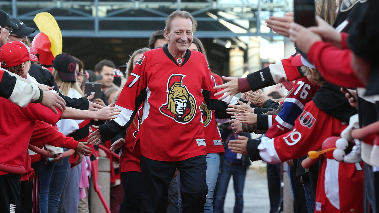 OTTAWA, ON - OCTOBER 11: Eugene Melnyk, owner of the Ottawa Senators, high-fives fans as he walks down the red carpet before the home opener against the Montreal Canadiens at Canadian Tire Centre on October 11, 2015 in Ottawa, Ontario, Canada.