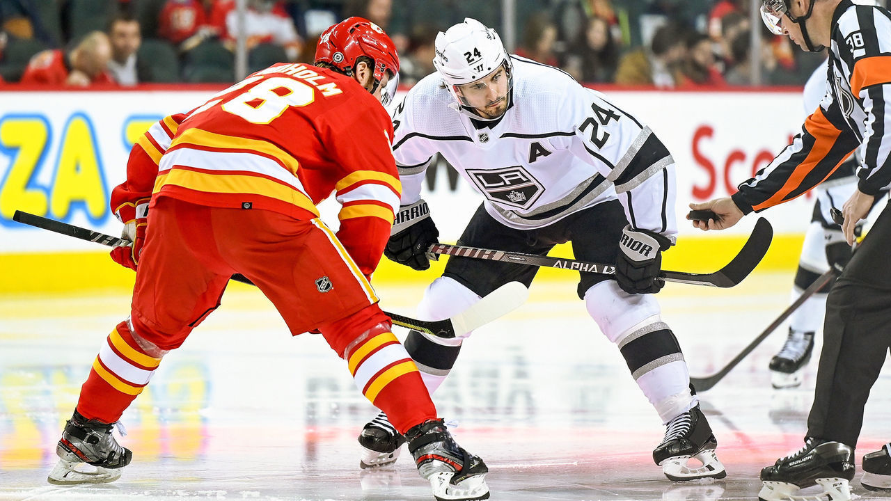 CALGARY, AB - MARCH 31: Calgary Flames Center Elias Lindholm (28) and Los Angeles Kings Center Phillip Danault (24) take a face-off during the third period of an NHL game where the Calgary Flames hosted the Los Angeles Kings on March 31, 2022, at the Scotiabank Saddledome in Calgary, AB.