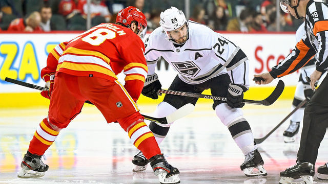 CALGARY, AB - MARCH 31: Calgary Flames Center Elias Lindholm (28) and Los Angeles Kings Center Phillip Danault (24) take a face-off during the third period of an NHL game where the Calgary Flames hosted the Los Angeles Kings on March 31, 2022, at the Scotiabank Saddledome in Calgary, AB.