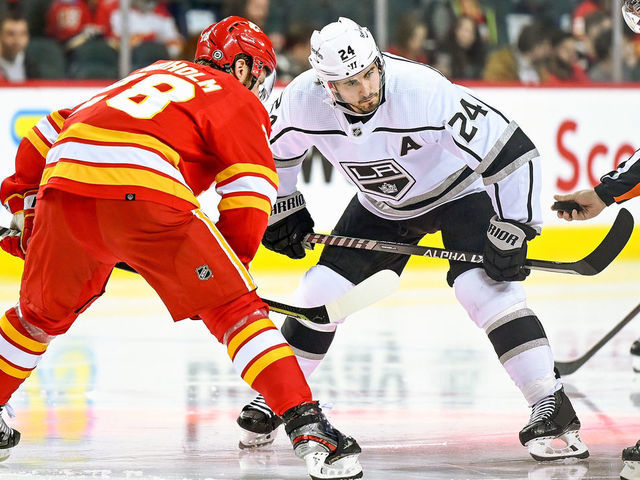 CALGARY, AB - MARCH 31: Calgary Flames Center Elias Lindholm (28) and Los Angeles Kings Center Phillip Danault (24) take a face-off during the third period of an NHL game where the Calgary Flames hosted the Los Angeles Kings on March 31, 2022, at the Scotiabank Saddledome in Calgary, AB.