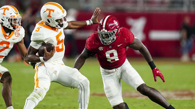 TUSCALOOSA, ALABAMA - OCTOBER 23: Hendon Hooker #5 of the Tennessee Volunteers tries to ge away from Christian Harris #8 of the Alabama Crimson Tide at Bryant Denny Stadium on October 23, 2021 in Tuscaloosa, Alabama