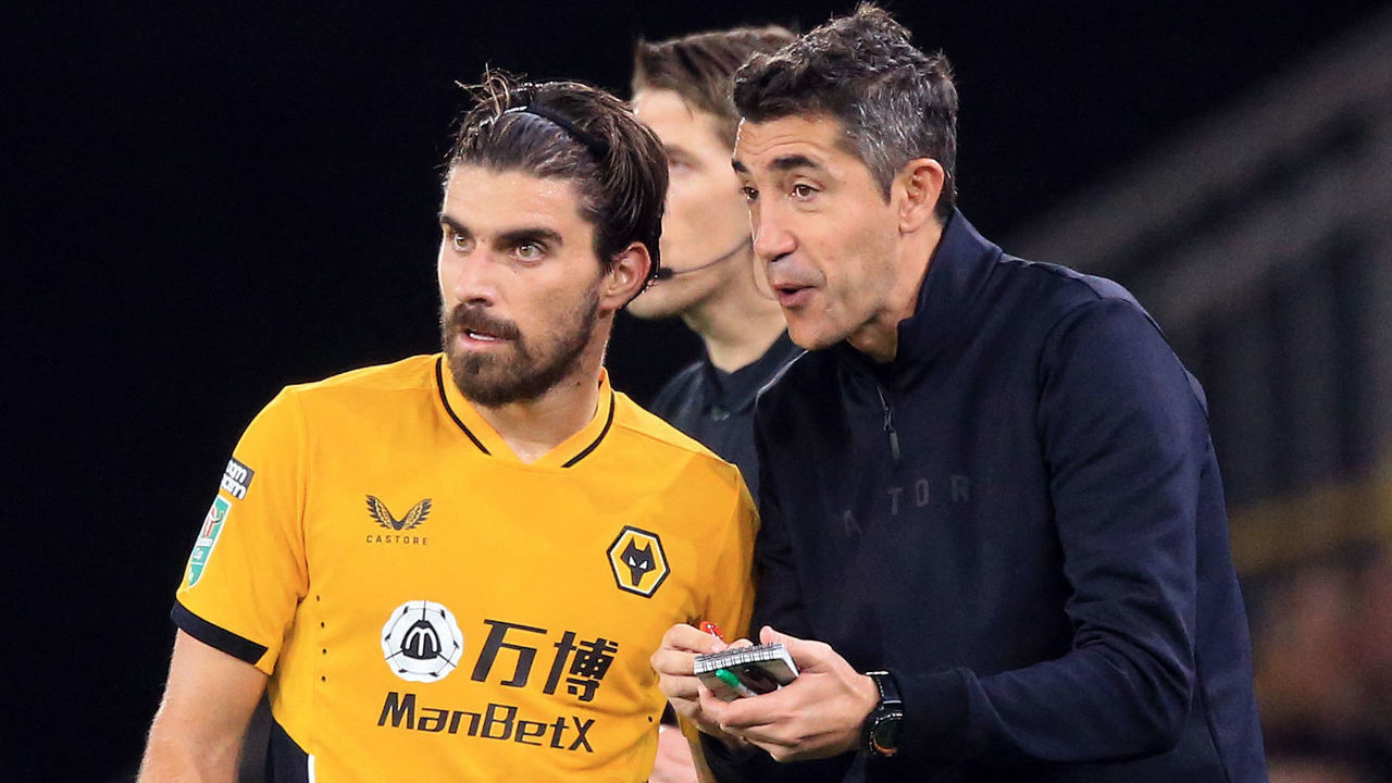 Wolverhampton Wanderers' Portuguese head coach Bruno Lage (R) speaks to Wolverhampton Wanderers' Portuguese midfielder Ruben Neves during the English League Cup third round football match between Wolverhampton Wanderers and Tottenham Hotspur at the Molineux stadium in Wolverhampton, central England on September 22, 2021. - RESTRICTED TO EDITORIAL USE. No use with unauthorized audio, video, data, fixture lists, club/league logos or 'live' services. Online in-match use limited to 120 images. An additional 40 images may be used in extra time. No video emulation. Social media in-match use limited to 120 images. An additional 40 images may be used in extra time. No use in betting publications, games or single club/league/player publications.