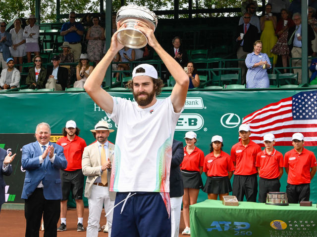 HOUSTON, TX - APRIL 10: Reilly Opelka (USA) hoists the trophy for winning the US Clay Court Championships singles finals match between Reilly Opelka (USA) and John Isner (USA) at River Oaks Country Club on April 10, 2022 in Houston, TX.