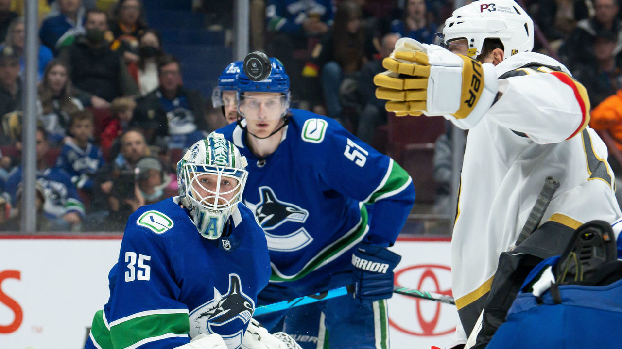 VANCOUVER, BC - APRIL 03: Vancouver Canucks goaltender Thatcher Demko (35) watches Vegas Golden Knights center Nicolas Roy (10) reach for the puck during their NHL game at Rogers Arena on April 3, 2022 in Vancouver, British Columbia, Canada.