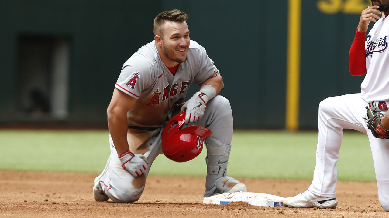 ARLINGTON, TEXAS - APRIL 17: Mike Trout #27 of the Los Angeles Angels reacts after hitting a double in the third inning as Marcus Semien #2 of the Texas Rangers looks on at Globe Life Field on April 17, 2022 in Arlington, Texas.
