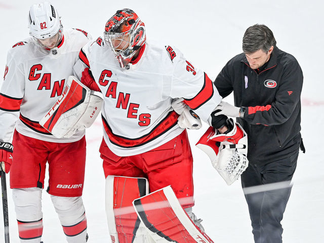 DENVER, COLORADO - APRIL 16: Frederik Andersen #31 of the Carolina Hurricanes is helped off the ice by teammate Jesperi Kotkaniemi #82 and a trainer in the third period of a game against the Colorado Avalanche at Ball Arena on April 16, 2022 in Denver, Colorado.