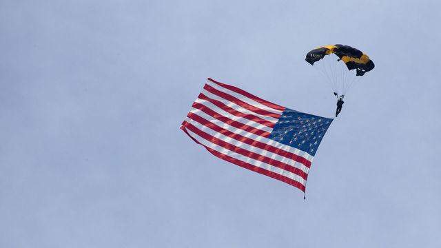 A member of the U.S. Army Golden Knights parachute team carries an American flag landing on the South Lawn of the White House during the Salute to America event in Washington, D.C., U.S., on Saturday, July 4, 2020. President Donald Trump yesterday decried what he described as efforts to eliminate U.S. history and malign heroes, lashing out at those protesting symbols they say celebrate racial injustice as he stoked culture wars over history and education. Photographer: Stefani Reynolds/CNP/Bloomberg via Getty Images
