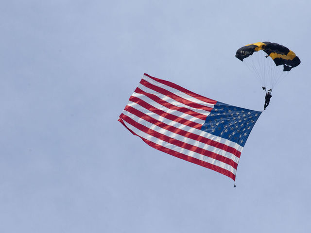 A member of the U.S. Army Golden Knights parachute team carries an American flag landing on the South Lawn of the White House during the Salute to America event in Washington, D.C., U.S., on Saturday, July 4, 2020. President Donald Trump yesterday decried what he described as efforts to eliminate U.S. history and malign heroes, lashing out at those protesting symbols they say celebrate racial injustice as he stoked culture wars over history and education. Photographer: Stefani Reynolds/CNP/Bloomberg via Getty Images