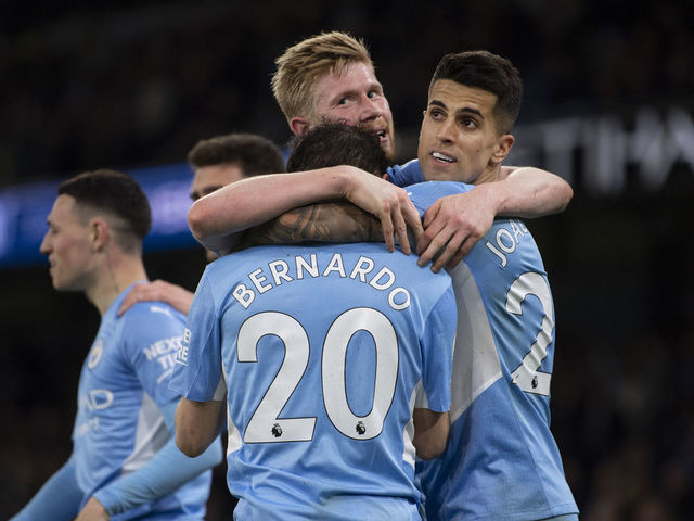 MANCHESTER, ENGLAND - APRIL 20: Bernardo Silva of Manchester City celebrates scoring the third goal with team mates Kevin De Bruyne and Joao Cancelo during the Premier League match between Manchester City and Brighton & Hove Albion at Etihad Stadium on April 20, 2022 in Manchester, United Kingdom.