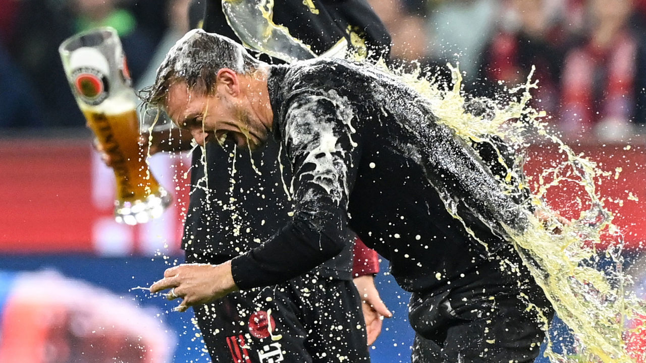 23 April 2022, Bavaria, Munich: Soccer: Bundesliga, Bayern Munich - Borussia Dortmund, Matchday 31, Allianz Arena. Munich head coach Julian Nagelsmann gets a beer shower. (RECROP) IMPORTANT NOTICE: In accordance with the requirements of the DFL Deutsche Fußball Liga and/or the DFB Deutscher Fußball-Bund, it is prohibited to exploit or have exploited photographs taken in the stadium and/or of the match in the form of sequence pictures and/or video-like photo series. Photo: Matthias Balk/dpa
