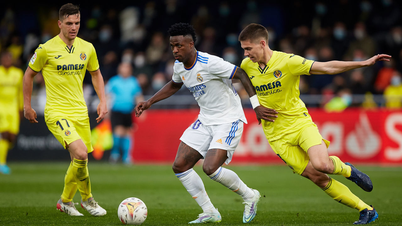 Vinicius Junior (C) of Real Madrid CF competes for the ball with Juan Marcos Foyth (R) and Lo Celso of Villarreal CF during the La Liga Santander match between Villarreal CF and Real Madrid CF at Estadio de la Ceramica on February 12, 2022, Villarreal, Spain