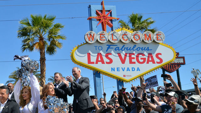 LAS VEGAS, NV - APRIL 29: Nevada Gov. Brian Sandoval (L, front) announces David Sharpe of Florida as the Oakland Raiders' fourth-round draft pick in the 2017 NFL Draft at the Welcome to Fabulous Las Vegas sign on April 29, 2017 in Las Vegas, Nevada. National Football League owners voted in March to approve the team's application to relocate to Las Vegas. The Raiders are expected to begin play no later than 2020 in a planned 65,000-seat domed stadium to be built in Las Vegas at a cost of about USD 1.9 billion.