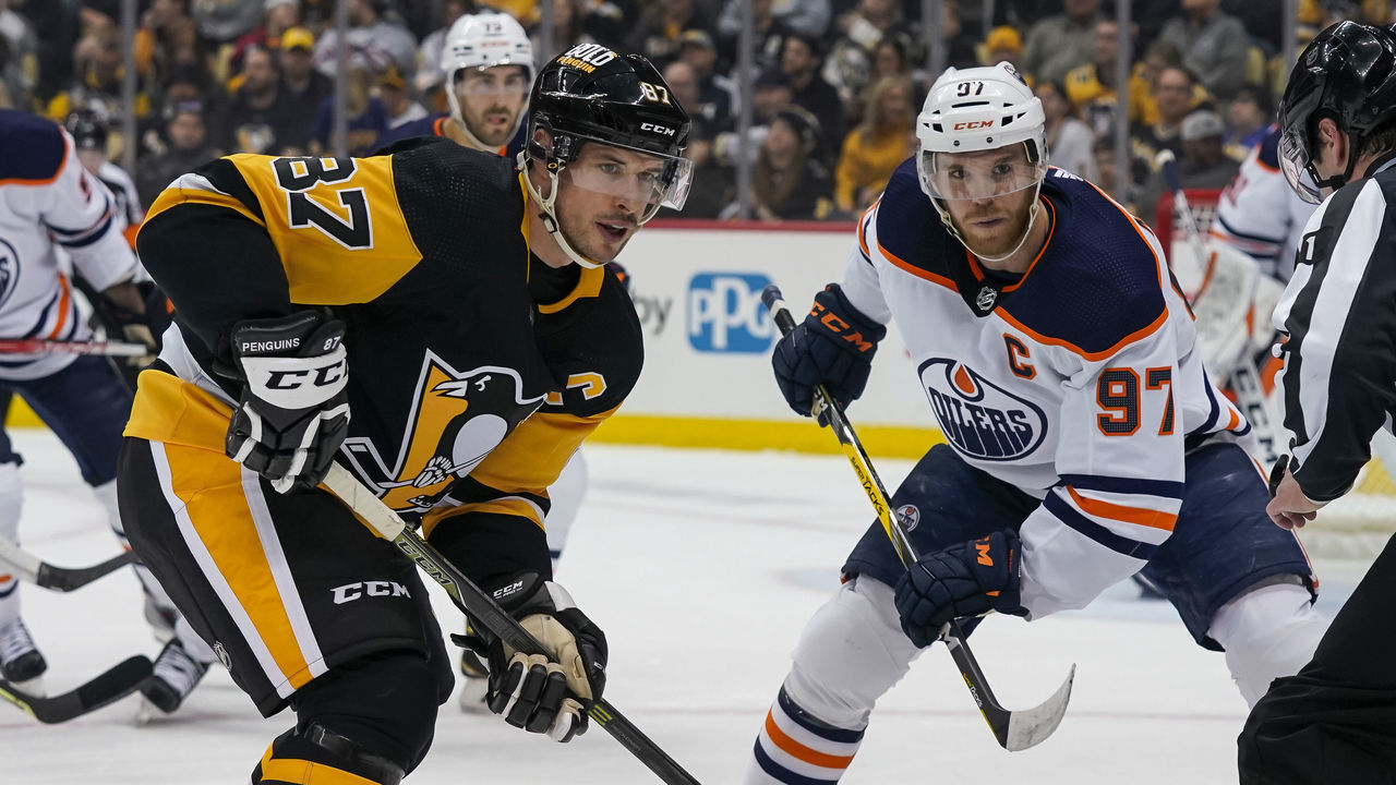 PITTSBURGH, PA - APRIL 26: Pittsburgh Penguins Center Sidney Crosby (87) and Edmonton Oilers Center Connor McDavid (97) face-off during the first period in the NHL game between the Pittsburgh Penguins and the Edmonton Oilers on April 26, 2022, at PPG Paints Arena in Pittsburgh, PA.