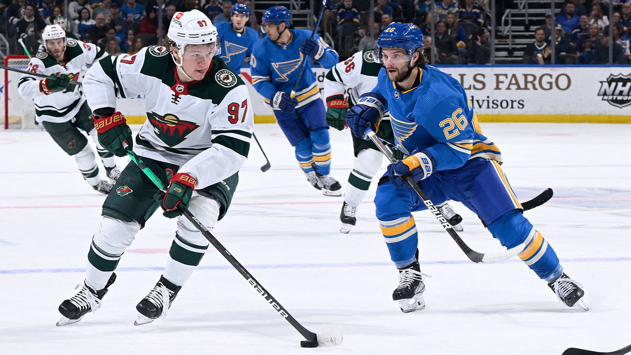 ST. LOUIS, MO - APRIL 16: Nathan Walker #26 of the St. Louis Blues pressures Kirill Kaprizov #97 of the Minnesota Wild at the Enterprise Center on April 16, 2022 in St. Louis, Missouri.