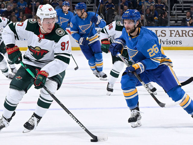 ST. LOUIS, MO - APRIL 16: Nathan Walker #26 of the St. Louis Blues pressures Kirill Kaprizov #97 of the Minnesota Wild at the Enterprise Center on April 16, 2022 in St. Louis, Missouri.