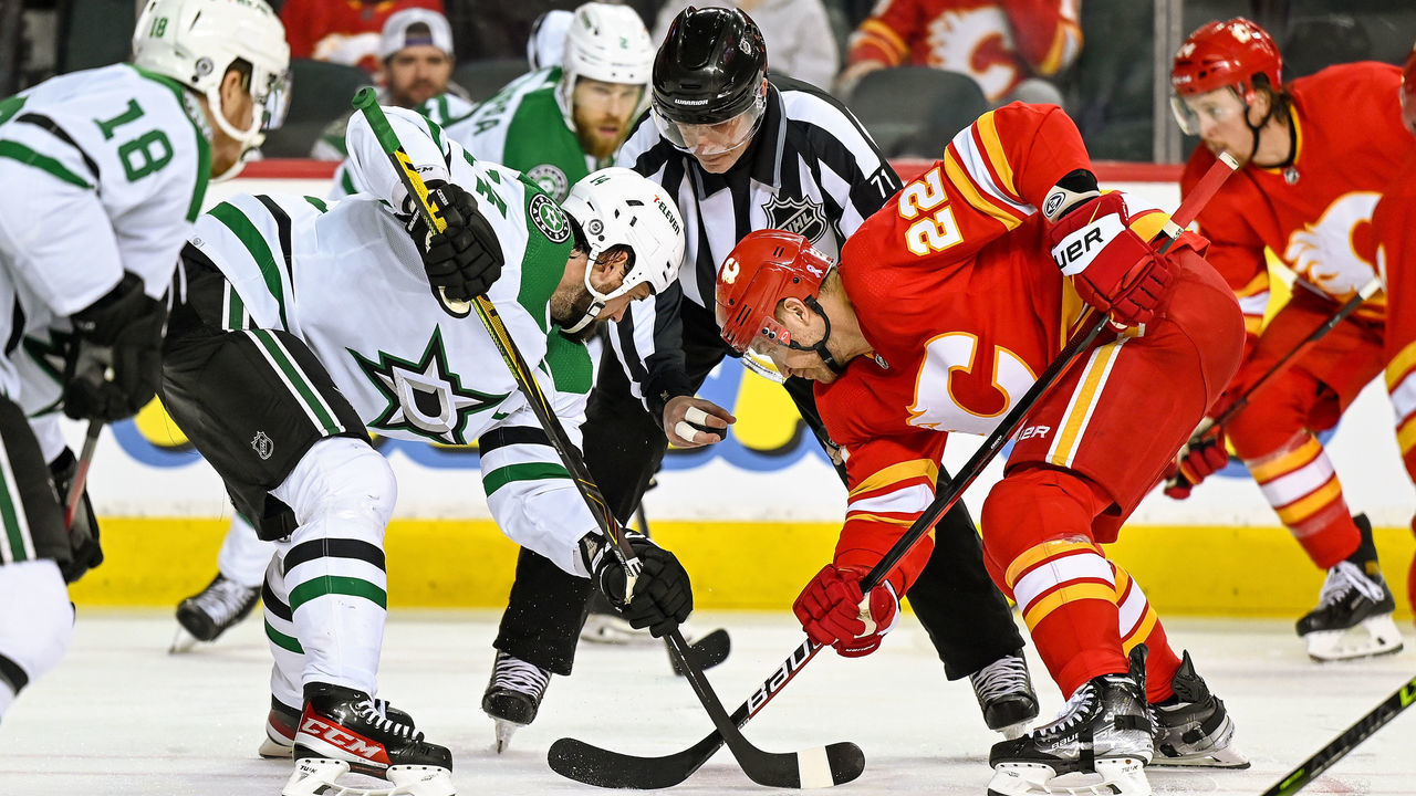 CALGARY, AB - APRIL 21: Dallas Stars Center Jamie Benn (14) and Calgary Flames Center Trevor Lewis (22) take a face-off during the second period of an NHL game where the Calgary Flames hosted the Dallas Stars on April 21, 2022, at the Scotiabank Saddledome in Calgary, AB.