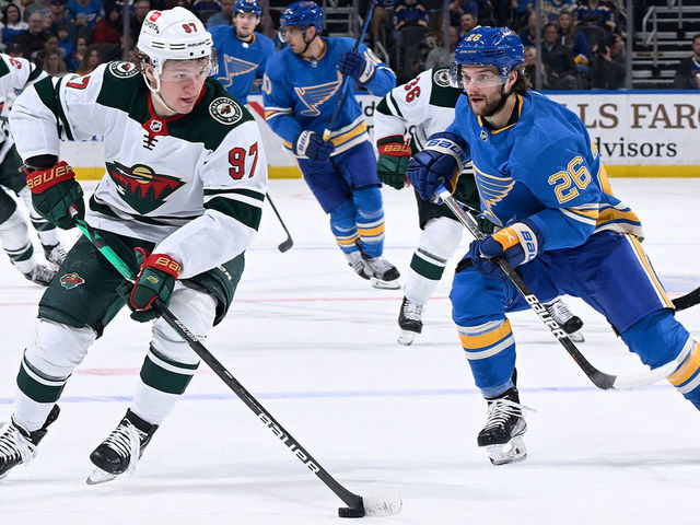 ST. LOUIS, MO - APRIL 16: Nathan Walker #26 of the St. Louis Blues pressures Kirill Kaprizov #97 of the Minnesota Wild at the Enterprise Center on April 16, 2022 in St. Louis, Missouri.