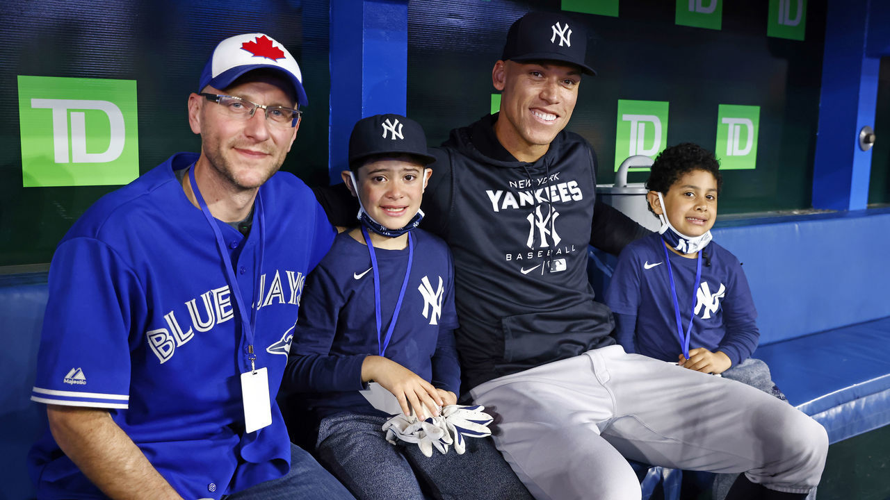 TORONTO, ON - MAY 4: Aaron Judge #99 of the New York Yankees meets with Toronto Blue Jays fan Mike Lanzillotta (L) and Yankee fan Derek Rodriguez, 9, (2nd L) prior to a MLB game against the Toronto Blue Jays at Rogers Centre on May 4, 2022 in Toronto, Ontario, Canada. A video of Rodriguez becoming emotional after receiving an Aaron Judge home-run ball from Toronto Blue Jays fan Mike Lanzillotta went viral on social media after Tuesday's game.