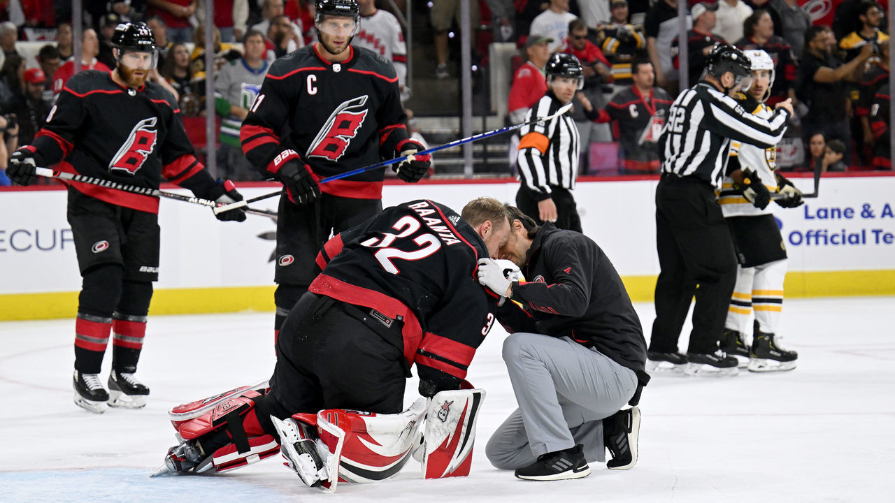 RALEIGH, NORTH CAROLINA - MAY 04: A trainer tends to Antti Raanta #32 of the Carolina Hurricanes after he was injured against the Boston Bruins during the first period of Game Two of the First Round of the 2022 Stanley Cup Playoffs at PNC Arena on May 04, 2022 in Raleigh, North Carolina.