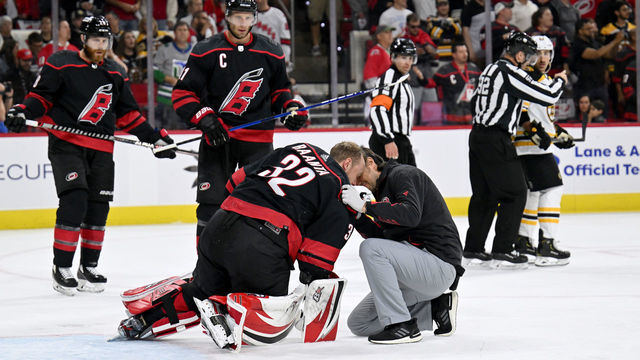 RALEIGH, NORTH CAROLINA - MAY 04: A trainer tends to Antti Raanta #32 of the Carolina Hurricanes after he was injured against the Boston Bruins during the first period of Game Two of the First Round of the 2022 Stanley Cup Playoffs at PNC Arena on May 04, 2022 in Raleigh, North Carolina.