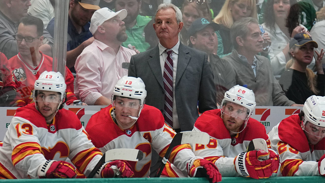 DALLAS, TX - MAY 7: Darryl Sutter pf the Calgary Flames watches the action from behind the bench against the Dallas Stars in Game Three of the First Round of the 2022 Stanley Cup Playoffs at the American Airlines Center on May 7, 2022 in Dallas, Texas.