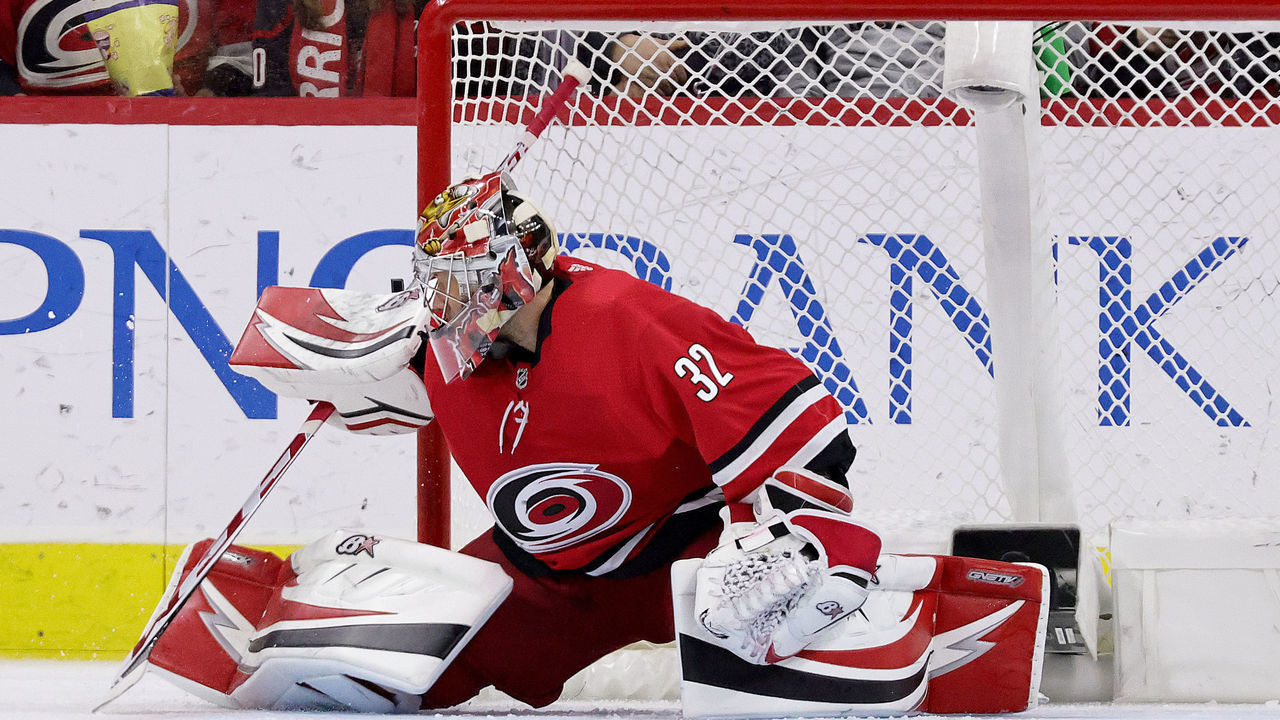 RALEIGH, NC - APRIL 28: Antti Raanta #32 of the Carolina Hurricanes does the splits in the crease and deflects the puck away during an NHL game against the New Jersey Devils on April 28, 2022 at PNC Arena in Raleigh, North Carolina.