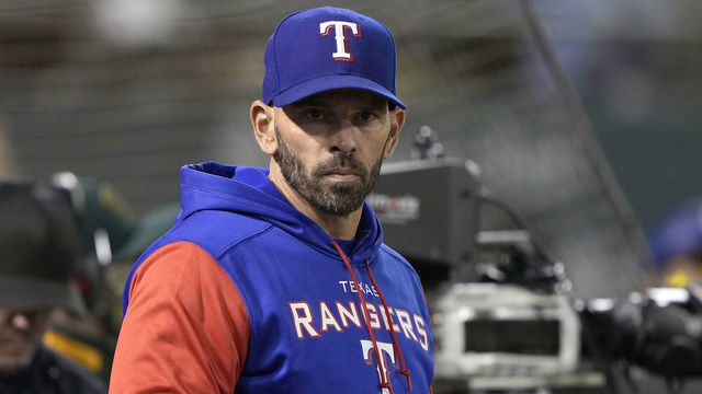 OAKLAND, CALIFORNIA - APRIL 22: Manager Chris Woodward #8 of the Texas Rangers looks on from the dugout against the Oakland Athletics in the bottom of the eighth inning at RingCentral Coliseum on April 22, 2022 in Oakland, California.