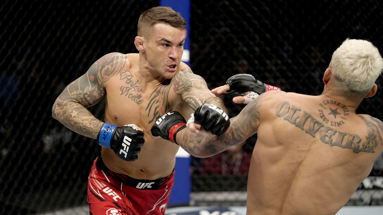 LAS VEGAS, NEVADA - DECEMBER 11: (L-R) Dustin Poirier punches Charles Oliveira of Brazil in their UFC lightweight championship bout during the UFC 269 on December 11, 2021 in Las Vegas, Nevada.