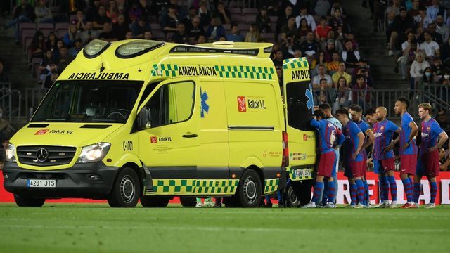 Barcelona's players stand near the ambulance during the evacuation of Uruguayan defender Ronald Araujo after an injury, during the Spanish league football match between FC Barcelona and RC Celta de Vigo at the Camp Nou stadium in Barcelona on May 10, 2022.