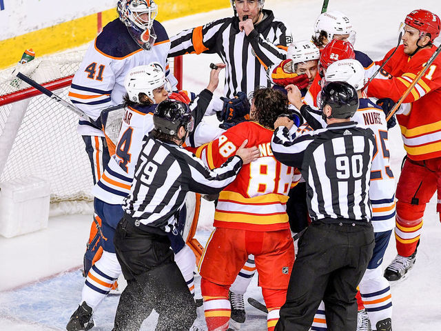 CALGARY, AB - APRIL 10: Calgary Flames Right Wing Andrew Mangiapane (88) and Edmonton Oilers Defenceman William Lagesson (84) rough one another after the whistle during the second period of an NHL game where the Calgary Flames hosted the Edmonton Oilers on April 10, 2021, at the Scotiabank Saddledome in Calgary, AB.