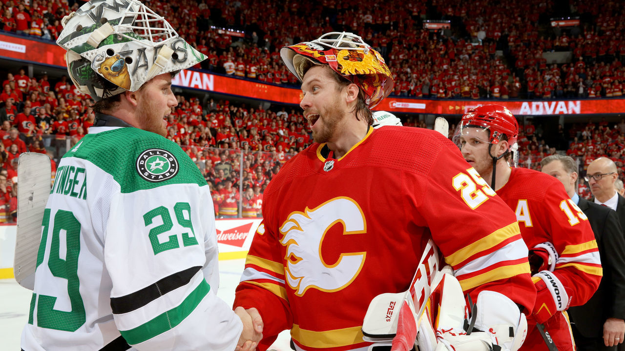CALGARY, ALBERTA - MAY 15: Jacob Markstrom #25 of the Calgary Flames shakes hands with Jake Oettinger #29 after a series win against the Dallas Stars in Game Seven of the First Round of the 2022 Stanley Cup Playoffs at Scotiabank Saddledome on May 15, 2022 in Calgary, Alberta.