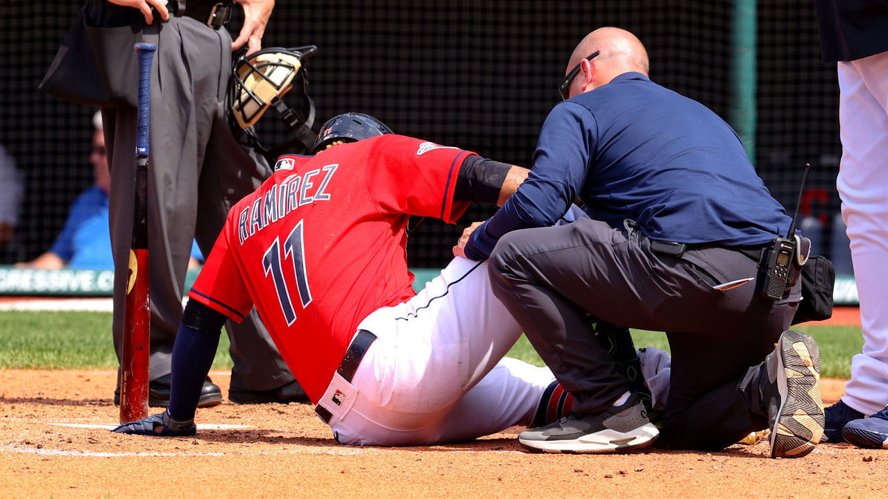 CLEVELAND, OH - MAY 19: Home plate umpire Jerry Meals (41), Cleveland Guardians manager Terry Francona (77) and Cincinnati Reds catcher Tyler Stephenson (37) look on as Cleveland Guardians third baseman Jose Ramirez (11) is examined after fouling a pitch off his shin during the eighth inning of the Major League Baseball Interleague game between the Cincinnati Reds and Cleveland Guardians on May 19, 2022, at Progressive Field in Cleveland, OH.