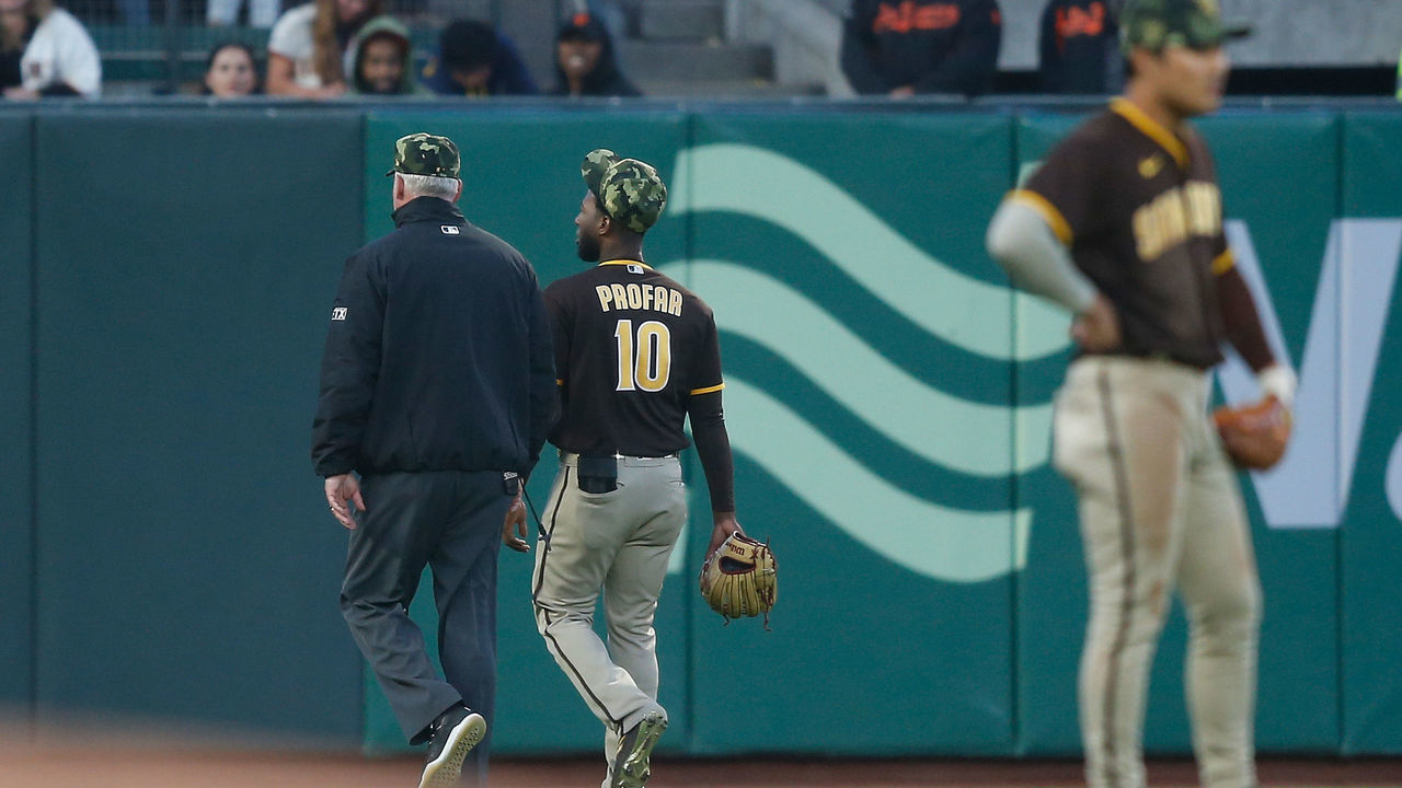 SAN FRANCISCO, CALIFORNIA - MAY 20: Jurickson Profar #10 of the San Diego Padres walks to left field with second base umpire Nestor Cejas #103 during a delay in play before the bottom of the third inning against the San Francisco Giants at Oracle Park on May 20, 2022 in San Francisco, California.