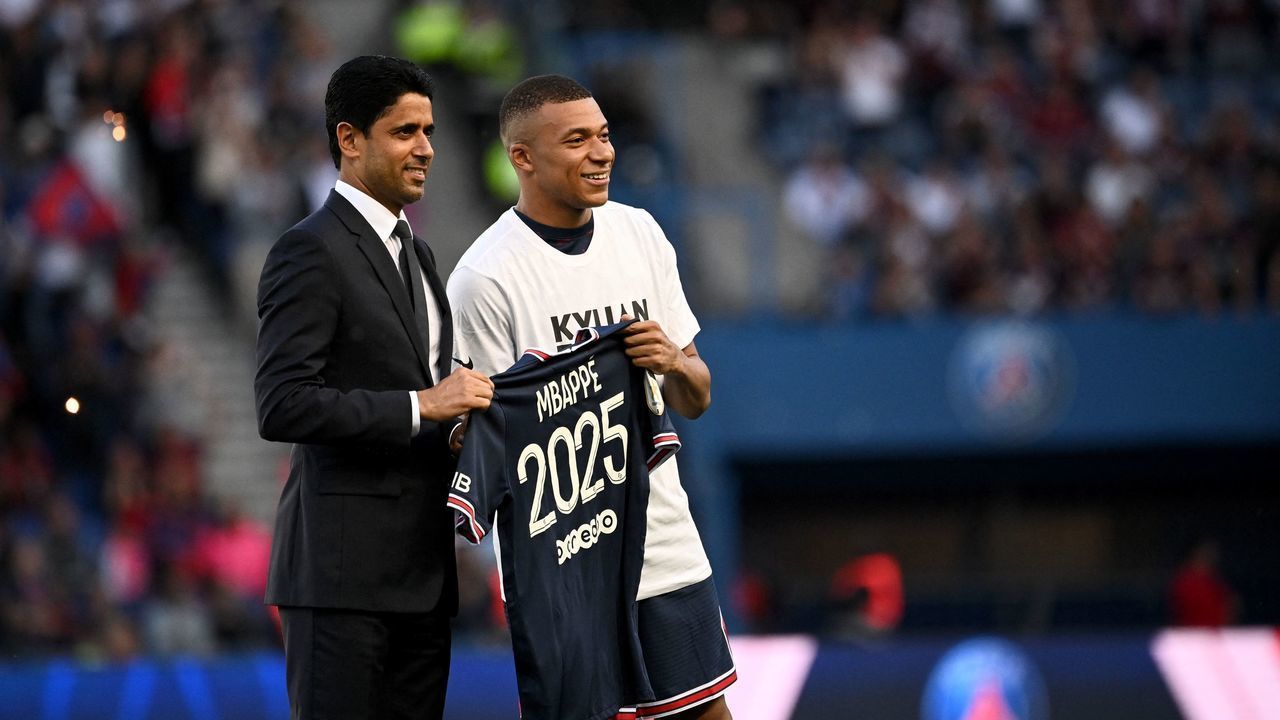 Paris Saint-Germain's French forward Kylian Mbappe (R) poses with PSG president Nasser Al-Khelaifi (L) after the announcement he staying at PSG until 2025 before the French L1 football match between Paris Saint-Germain (PSG) and Metz at the Parc des Princes stadium in Paris on May 21, 2022.