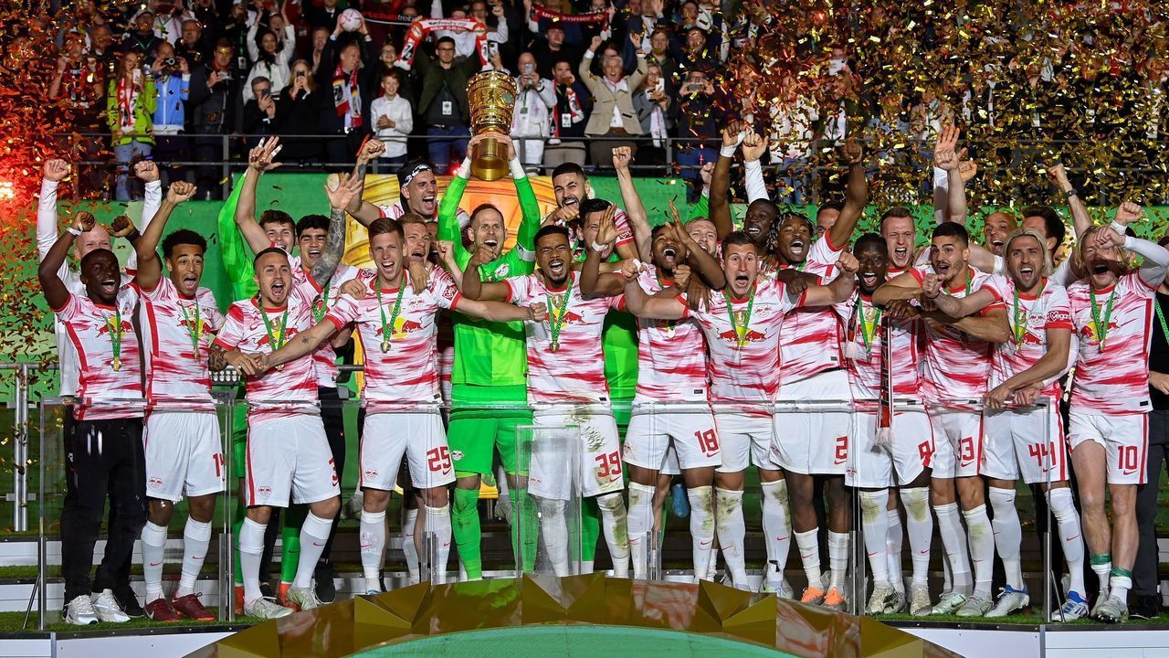 Leipzig's Hungarian goalkeeper Peter Gulacsi (C) and his teammates celebrate with the trophy after the German Cup final football match between SC Freiburg and RB Leipzig at the Olympic Stadium in Berlin on May 21, 2022. - Leipzig won the cup after a penalty shoot-out. - DFB REGULATIONS PROHIBIT ANY USE OF PHOTOGRAPHS AS IMAGE SEQUENCES AND QUASI-VIDEO.