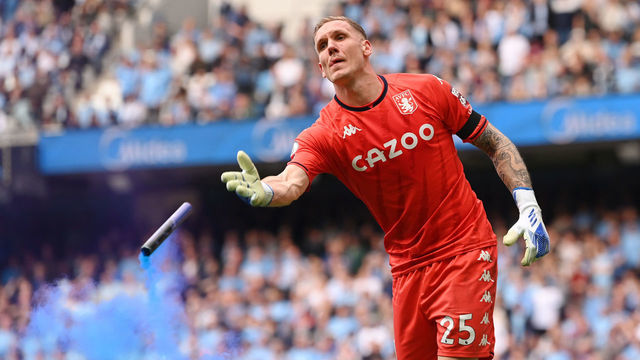 MANCHESTER, ENGLAND - MAY 22: Robin Olsen of Aston Villa removes a flare from the pitch during the Premier League match between Manchester City and Aston Villa at Etihad Stadium on May 22, 2022 in Manchester, England.