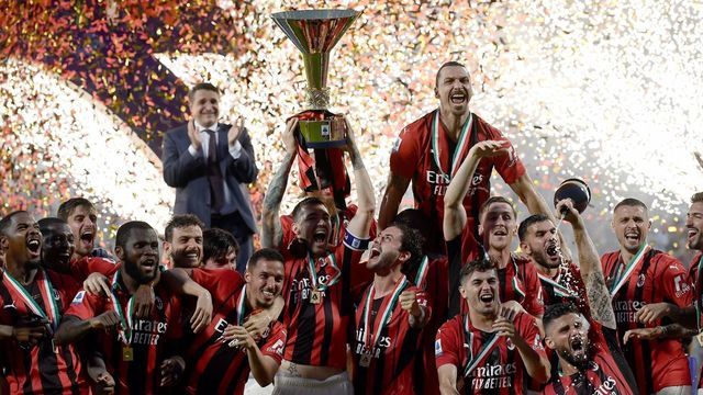 AC Milan's Italian defender Alessio Romagnoli (C-L with throphy), AC Milan's Swedish forward Zlatan Ibrahimovic (Top R), AC Milan's French forward Olivier Giroud (Bottom R) and AC Milan's players celebrate with the winner's trophy after AC Milan won the Italian Serie A football match between Sassuolo and AC Milan, securing the "Scudetto" championship on May 22, 2022 at the Mapei - Citta del Tricolore stadium in Sassuolo.