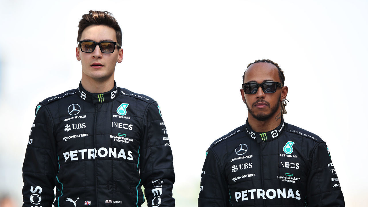 BAHRAIN, BAHRAIN - MARCH 10: George Russell of Great Britain and Mercedes and Lewis Hamilton of Great Britain and Mercedes walk in the Paddock during Day One of F1 Testing at Bahrain International Circuit on March 10, 2022 in Bahrain, Bahrain.