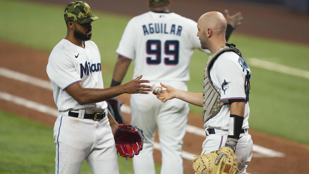 MIAMI, FLORIDA - MAY 22: Catcher Jacob Stallings #58 of the Miami Marlins hands the baseball to Sandy Alcantara #22 after he pitched a complete game against the Atlanta Braves at loanDepot park on May 22, 2022 in Miami, Florida.