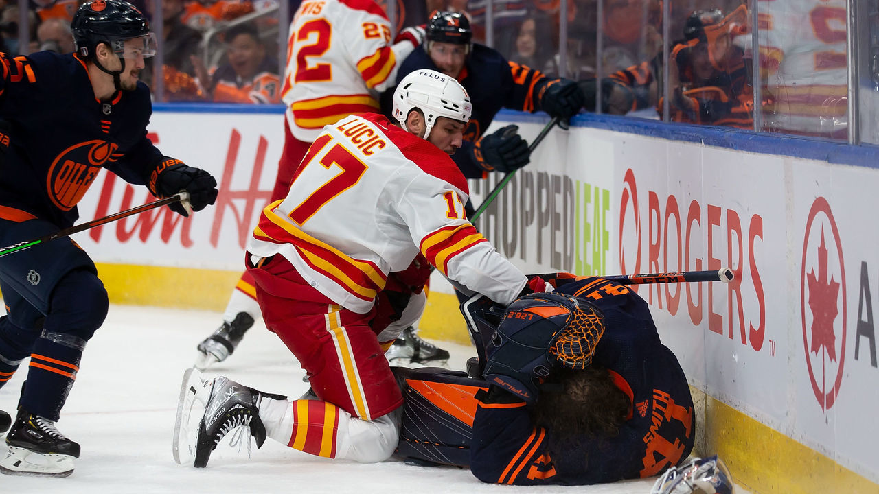 EDMONTON, AB - MAY 22: Goaltender Mike Smith #41 of the Edmonton Oilers is smashed into the boards by Milan Lucic #17 of the Calgary Flames during the third period in Game Three of the Second Round of the 2022 Stanley Cup Playoffs at Rogers Place on May 22, 2022 in Edmonton, Canada.