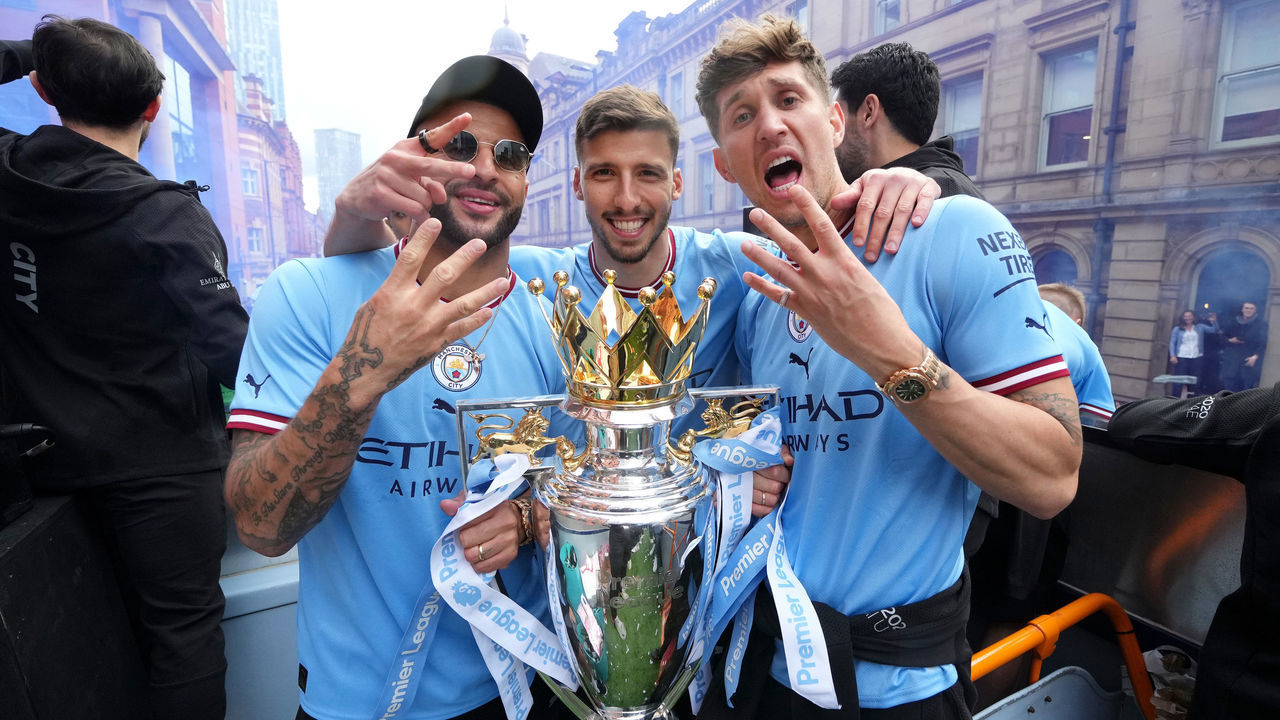 MANCHESTER, ENGLAND - MAY 23: Kyle Walker, Ruben Dias and John Stones of Manchester City pose for a photo with the Premier League trophy during the Manchester City FC Victory Parade on May 23, 2022 in Manchester, England.