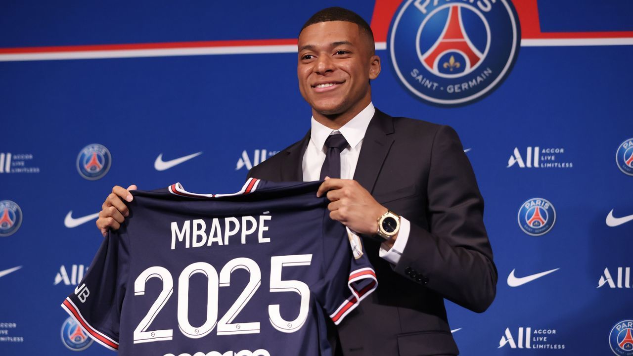 French forward Kylian Mbappe poses with a jersey at the end of a press conference at the Parc des Princes stadium in Paris on May 23, 2022, two days after the club won the Ligue 1 title for a record-equalling tenth time and its superstar striker Mbappe chose to sign a new contract until 2025 at PSG rather than join Real Madrid.