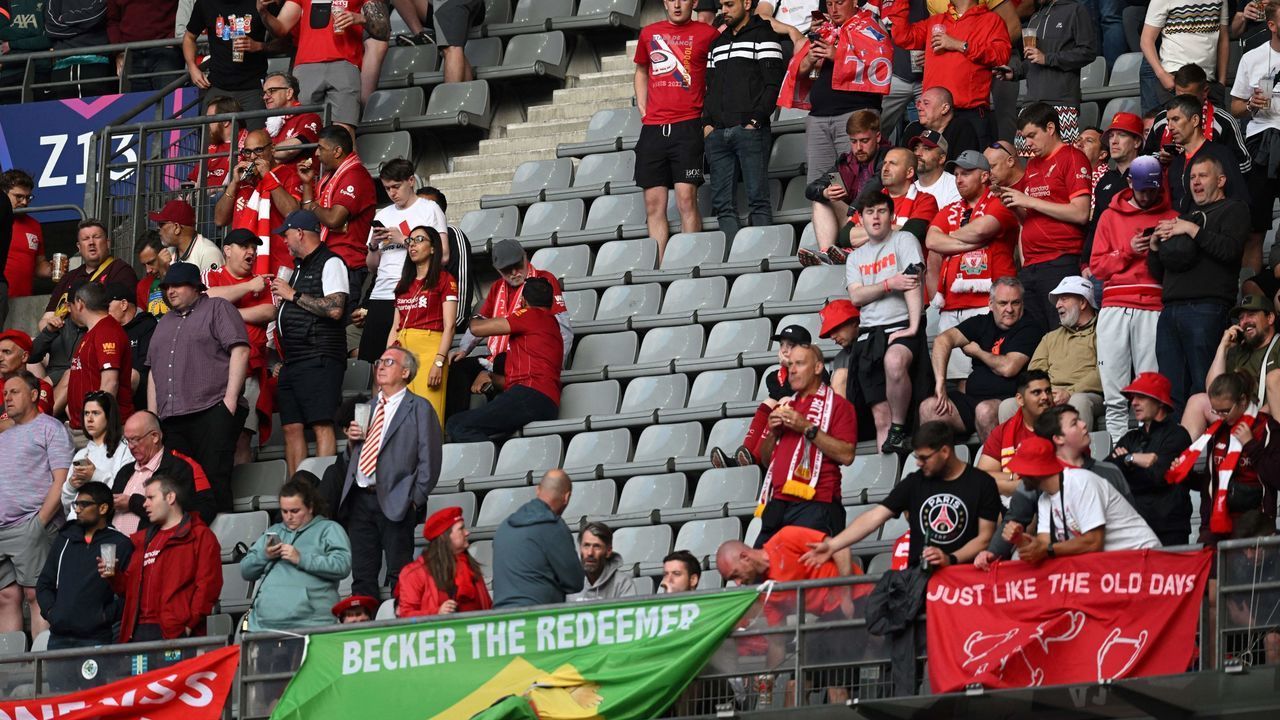 Liverpool's supporters cheer for their team next to empty seats as they wait for the start of the UEFA Champions League final football match between Liverpool and Real Madrid at the Stade de France in Saint-Denis, north of Paris, on May 28, 2022. - The kick-off of Champions League final between Liverpool and Real Madrid in Paris was delayed by 15 minutes "due to a security issue", UEFA said. The match was supposed to kick off at 9:00 pm (1900 GMT) at the Stade de France but announcements in the ground said the hold up was caused by the "late arrival" of supporters.