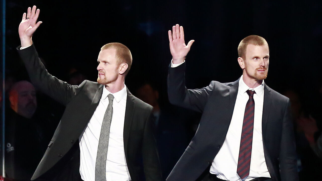 VANCOUVER, BC - FEBRUARY 12: Daniel (R) and Henrik Sedin walk onto the ice for their jersey retirement ceremony before the NHL game between the Vancouver Canucks and the Chicago Blackhawks at Rogers Arena February 12, 2020 in Vancouver, British Columbia, Canada. "n