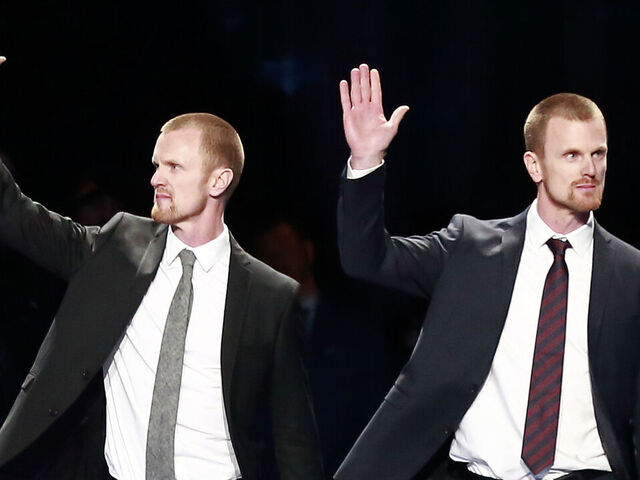 VANCOUVER, BC - FEBRUARY 12: Daniel (R) and Henrik Sedin walk onto the ice for their jersey retirement ceremony before the NHL game between the Vancouver Canucks and the Chicago Blackhawks at Rogers Arena February 12, 2020 in Vancouver, British Columbia, Canada. "n
