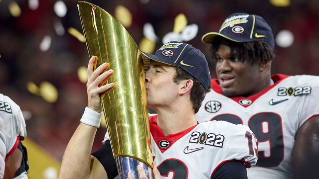 INDIANAPOLIS, IN - JANUARY 10: Georgia Bulldogs QB Stetson Bennett (13) celebrates and holds the national championship trophy after the Alabama Crimson Tide versus the Georgia Bulldogs in the College Football Playoff National Championship, on January 10, 2022, at Lucas Oil Stadium in Indianapolis, IN.