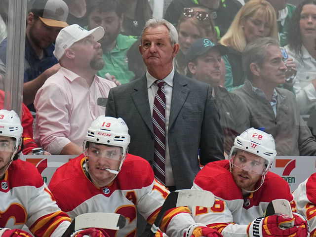 DALLAS, TX - MAY 7: Darryl Sutter pf the Calgary Flames watches the action from behind the bench against the Dallas Stars in Game Three of the First Round of the 2022 Stanley Cup Playoffs at the American Airlines Center on May 7, 2022 in Dallas, Texas.
