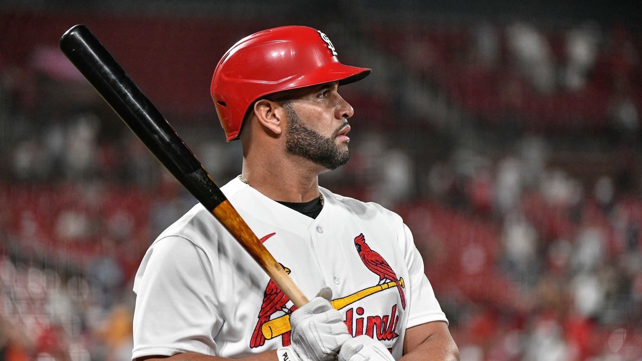 St. Louis Cardinals designated hitter Albert Pujols, left, jokes with San  Diego Padres third baseman Manny Machado after he was presented with a  surfboard from the Padres to honor his future retirement